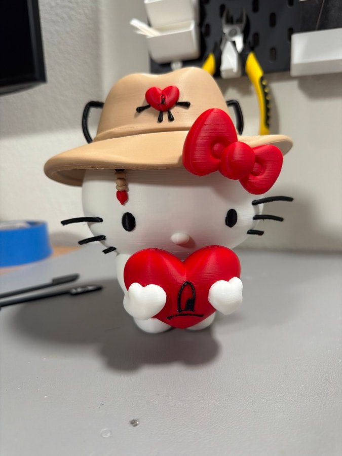 Kitty figure in a straw hat holding a red heart