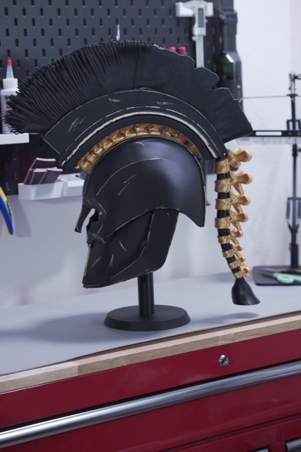 Black and gold Spartan helmet on a display stand